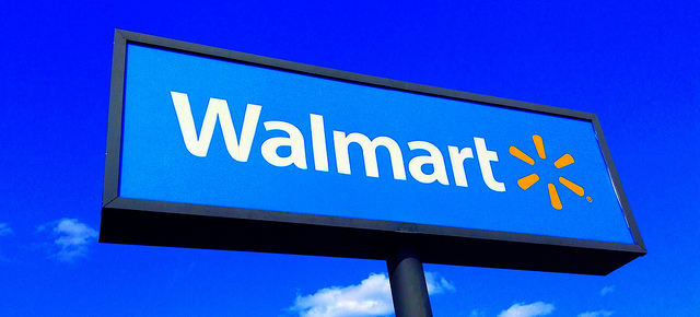 A tall Walmart sign against a clear, blue sky